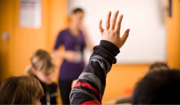 Young student raising their hand in a classroom