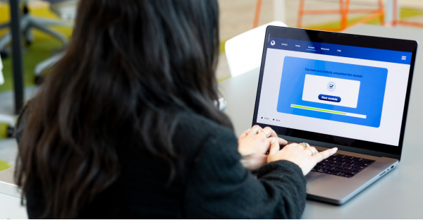 Woman working on a laptop whilst sitting at the table